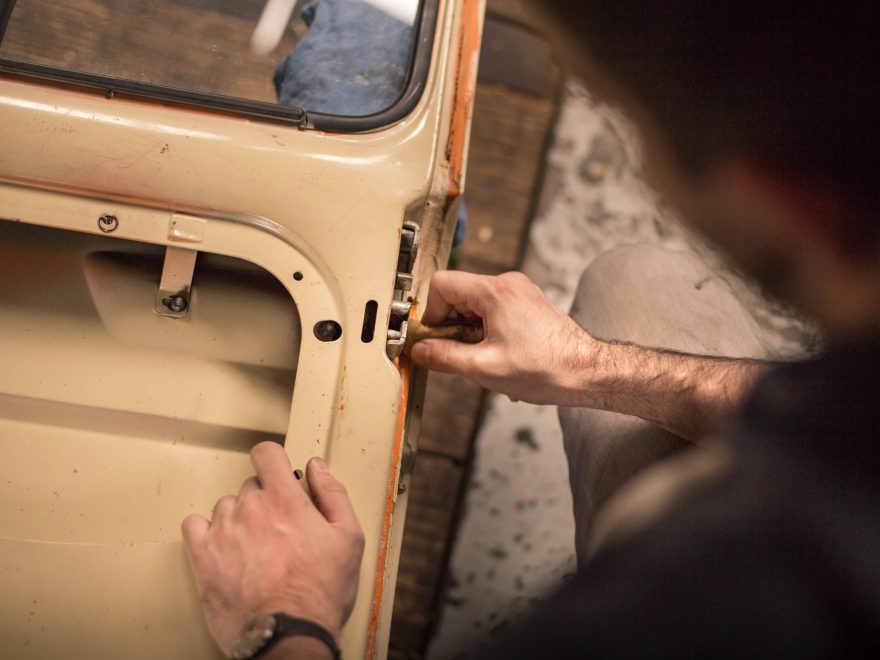 A man adjusting the lock mechanism on a car door